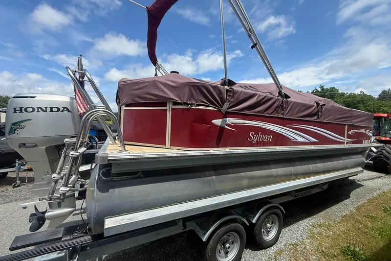 Slide: The Image of 2008 Sylvan 8523 Mandalay RE pontoon boat on trailer, covered, with Honda outboard motor. - 3