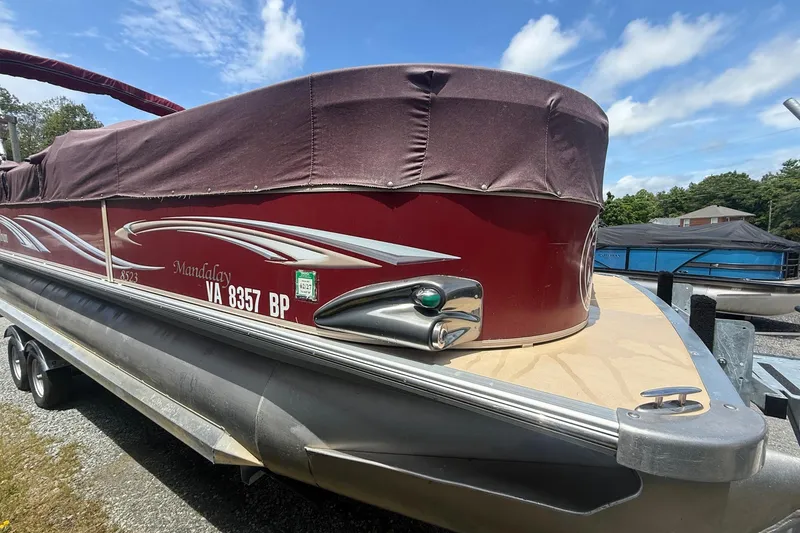 Slide: The Image of 2008 Sylvan 8523 Mandalay RE pontoon boat with maroon cover, parked on a trailer. - 6