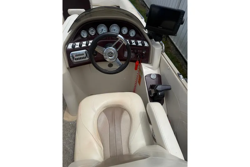 Slide: The Image of 2008 Sylvan 8523 Mandalay RE boat dashboard with steering wheel and control panel. - 8