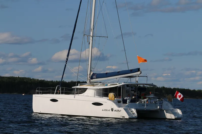 Slide: The Image of 2009 Fountaine Pajot Orana 44 catamaran sailing on a calm lake with a Canadian flag. - 13