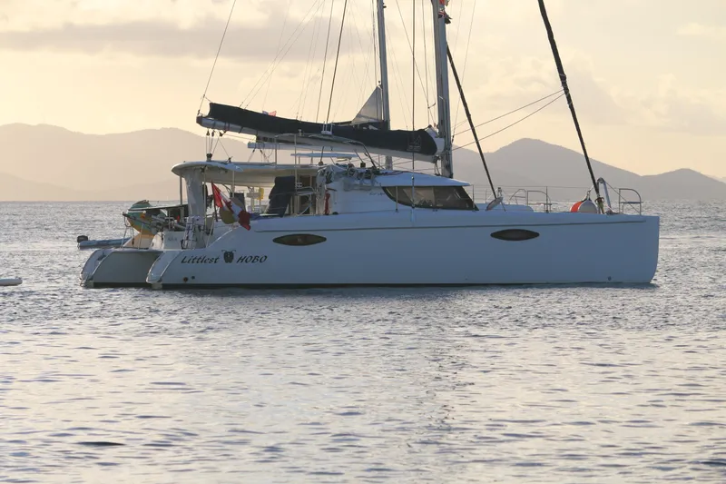 Slide: The Image of 2009 Fountaine Pajot Orana 44 catamaran sailing at sunset with scenic mountain backdrop. - 14