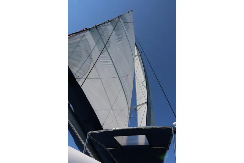 Slide: The Image of Sails of a 2009 Fountaine Pajot Orana 44 catamaran against a clear blue sky. - 15
