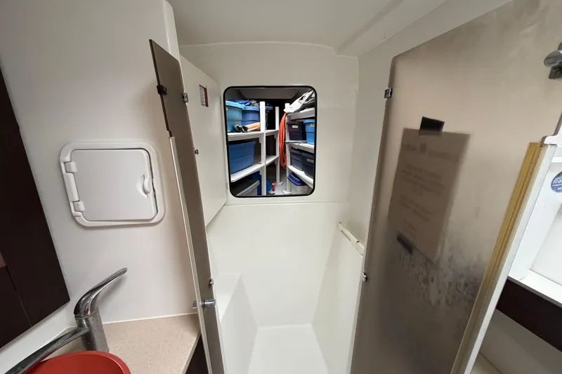 Slide: The Image of Interior of 2009 Fountaine Pajot Orana 44 catamaran, featuring compact bathroom and storage area. - 24