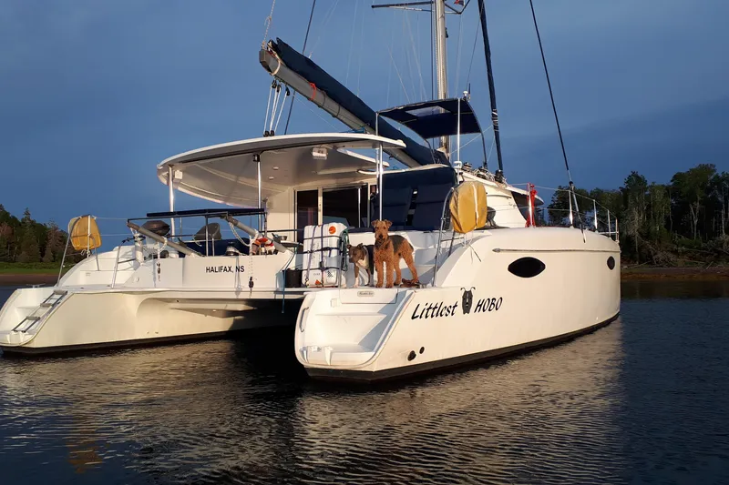 Slide: The Image of 2009 Fountaine Pajot Orana 44 catamaran with dogs on deck, moored in calm waters. - 3