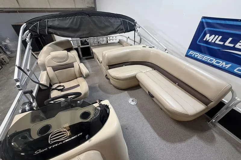 Slide: The Image of 2017 Sun Tracker Party Barge 22 DLX interior with beige seating and steering console. - 13