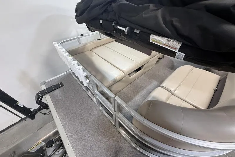 Slide: The Image of 2017 Sun Tracker Party Barge 22 DLX interior with beige seating and rod holders. - 5