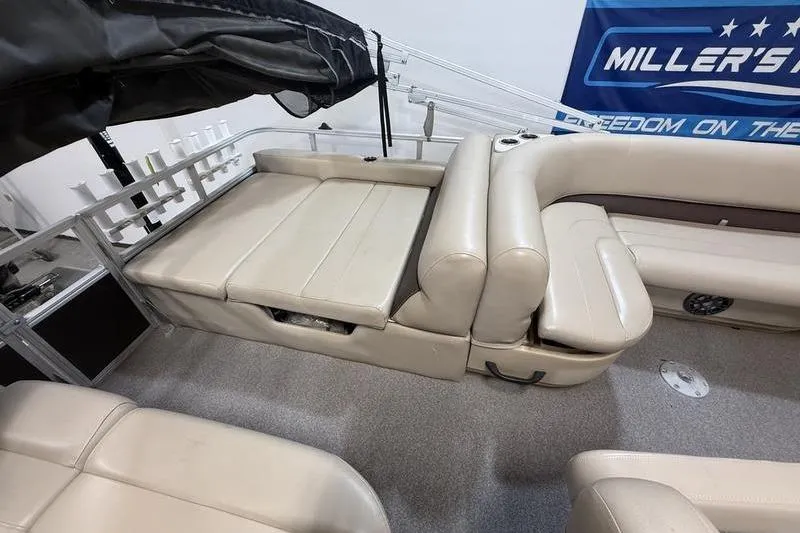 Slide: The Image of 2017 Sun Tracker Party Barge 22 DLX interior with beige seating and storage compartments. - 6