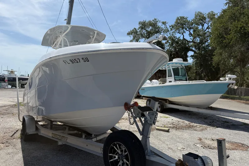 The Image of 2022 Aquasport 2300 Center Console boat on trailer, parked outdoors. - 1