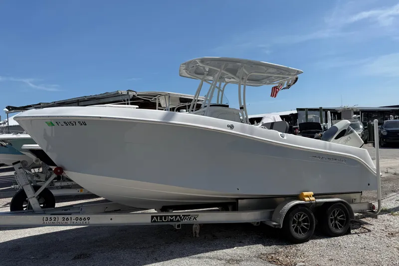 Slide: The Image of 2022 Aquasport 2300 Center Console boat on trailer under clear blue sky. - 3