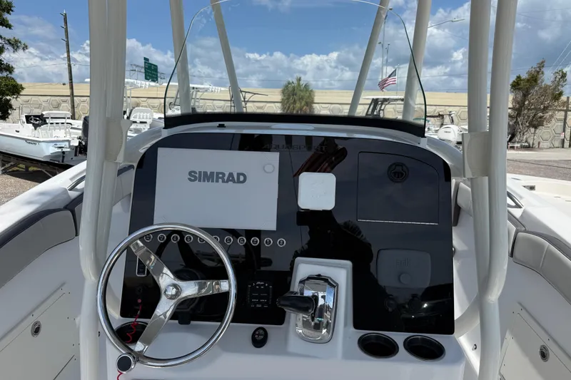 Slide: The Image of 2022 Aquasport 2300 Center Console helm with Simrad display and steering wheel. - 4