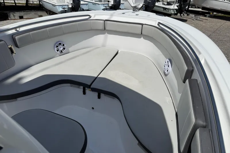 Slide: The Image of 2022 Aquasport 2300 Center Console boat interior with cushioned seating and speakers. - 5