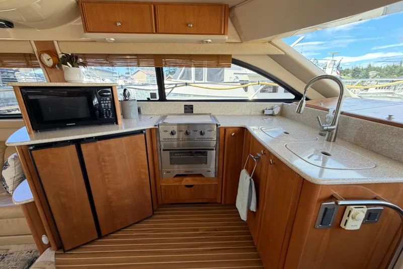 Slide: The Image of Luxurious 2004 Meridian 411 Sedan yacht kitchen with modern appliances and wooden cabinetry. - 10
