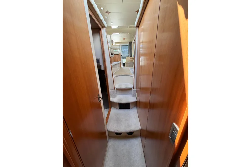 Slide: The Image of Interior hallway of 2004 Meridian 411 Sedan yacht with carpeted steps and wooden paneling. - 16