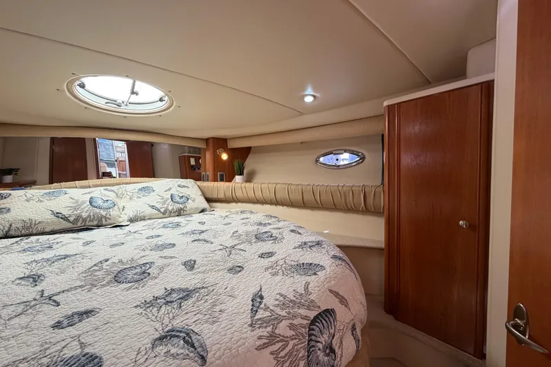 Slide: The Image of Luxurious 2004 Meridian 411 Sedan cabin with elegant bedding and wooden cabinetry. - 19