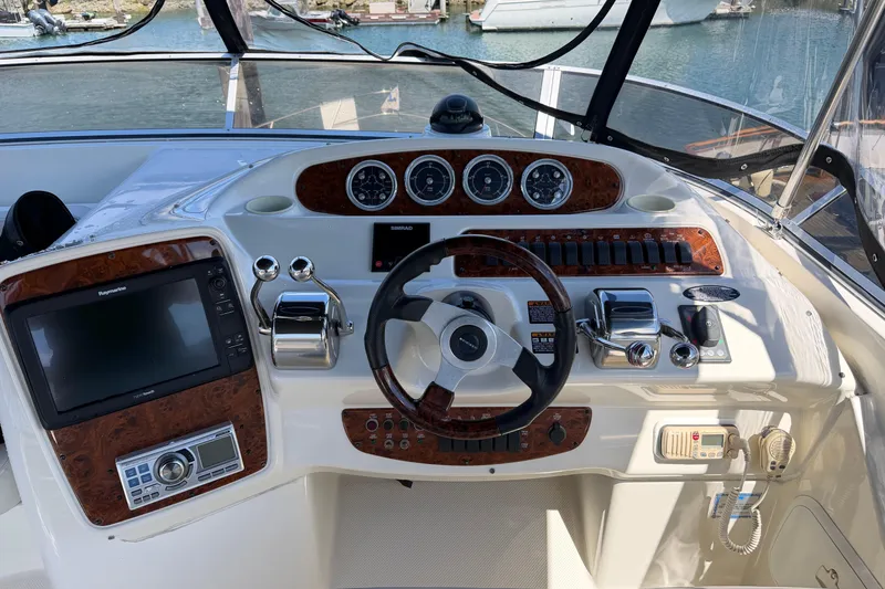 Slide: The Image of 2004 Meridian 411 Sedan helm with navigation controls and wood accents, docked at marina. - 29