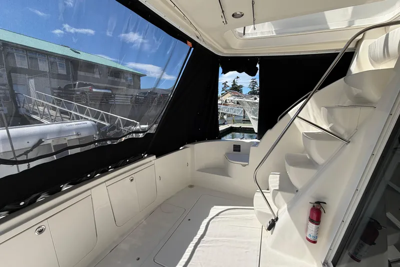 Slide: The Image of 2004 Meridian 411 Sedan yacht interior with stairs, black curtains, and dock view. - 38