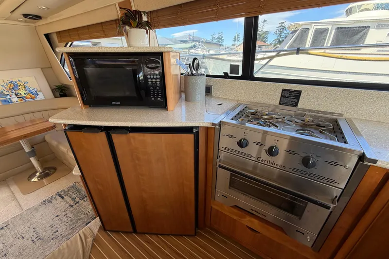 Slide: The Image of Kitchen area of a 2004 Meridian 411 Sedan yacht with stove, microwave, and seating. - 9