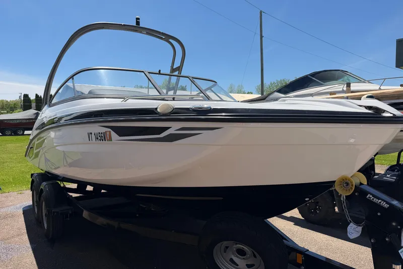 The Image of 2018 Yamaha Boats AR210 on trailer, parked outdoors under clear blue sky. - 0