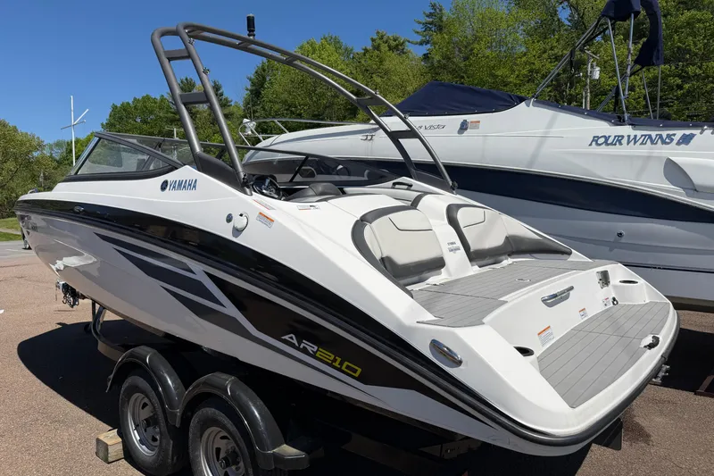 Slide: The Image of 2018 Yamaha Boats AR210 on trailer, sleek design, parked outdoors. - 2