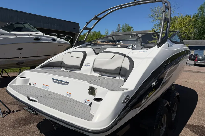 Slide: The Image of 2018 Yamaha Boats AR210, sleek design, white exterior, parked outdoors on a sunny day. - 3