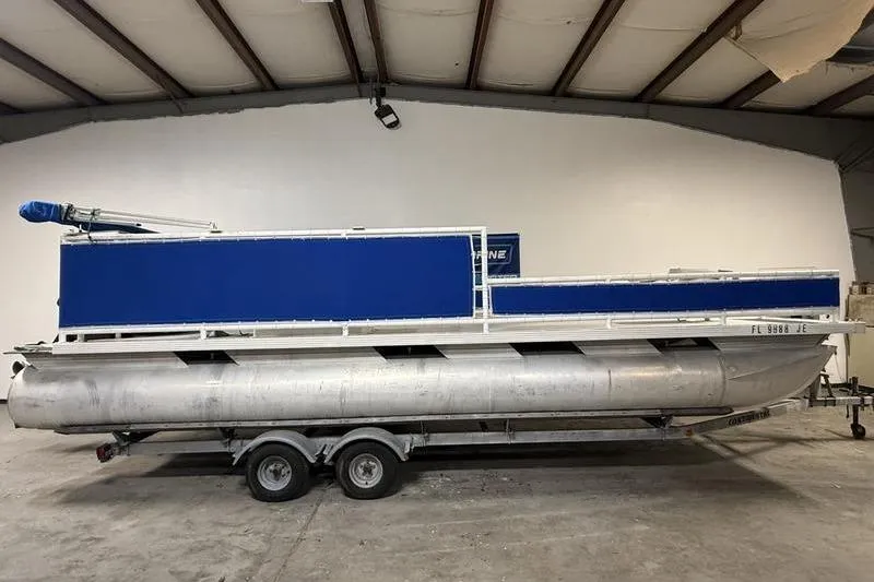 The Image of 1993 Monark Sun Caster 240 CR 4 Point pontoon boat in a warehouse setting. - 0