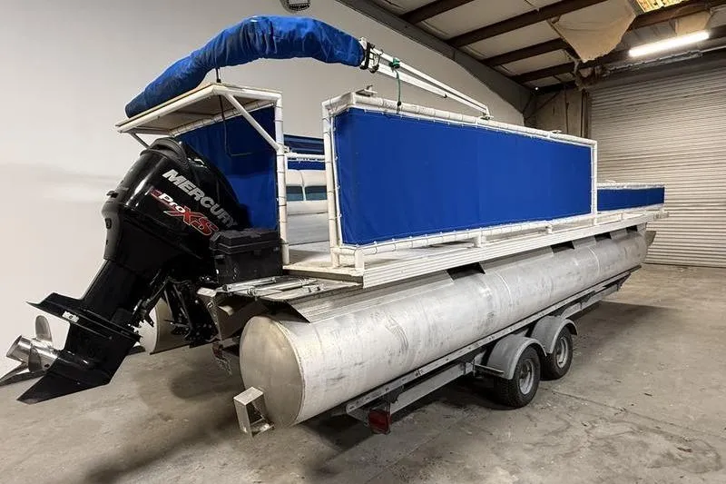 Slide: The Image of 1993 Monark Sun Caster 240 CR 4 Point pontoon boat with Mercury engine in a warehouse. - 2