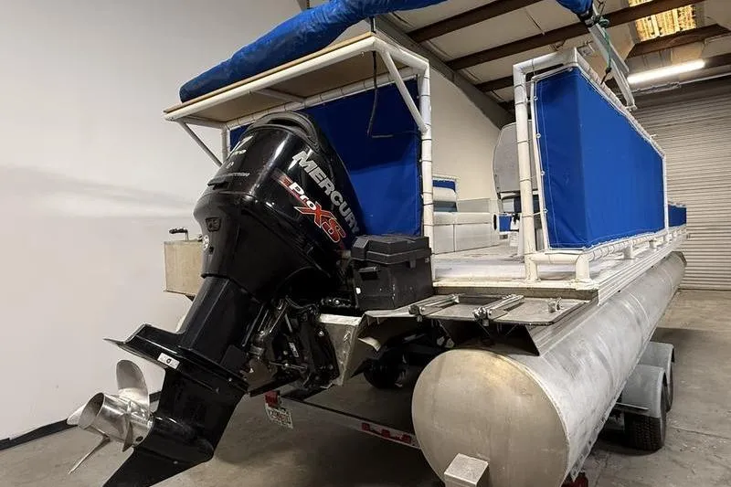 Slide: The Image of 1993 Monark Sun Caster 240 CR 4 Point pontoon boat with Mercury outboard motor in a garage. - 3