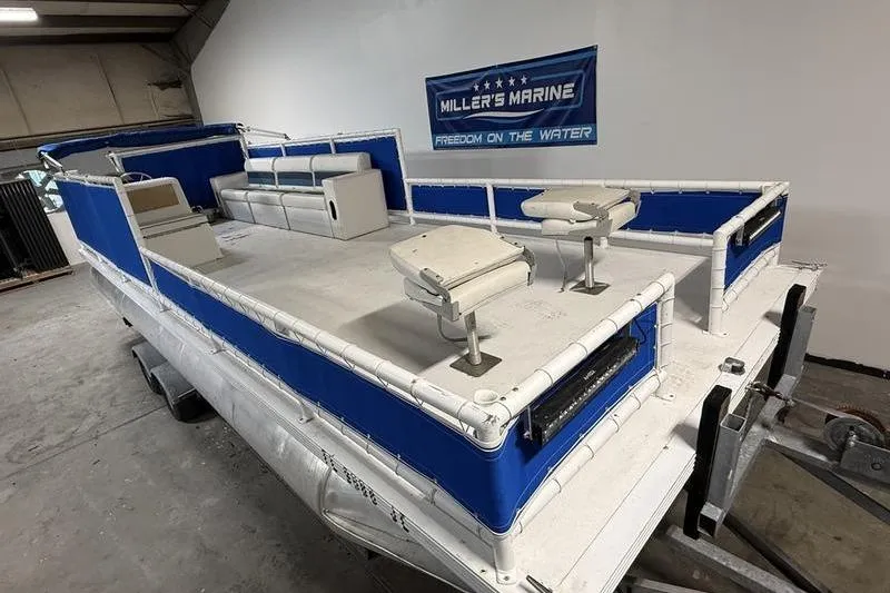 Slide: The Image of 1993 Monark Sun Caster 240 CR 4 Point pontoon boat in showroom, blue and white design. - 4