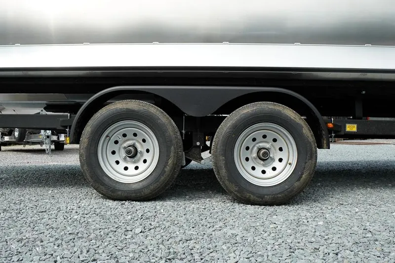 Slide: The Image of Dual wheels of 2026 SunCatcher Fusion 324RC trailer on gravel surface. - 12