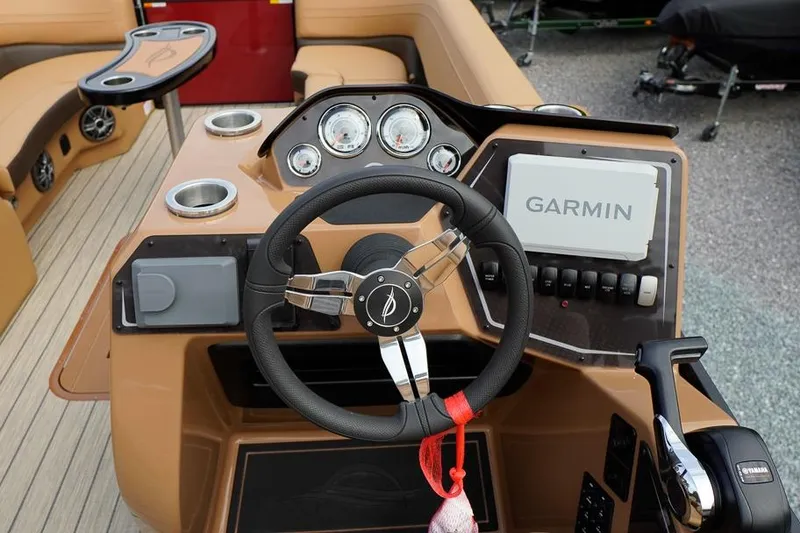Slide: The Image of 2026 SunCatcher Fusion 324RC boat dashboard with Garmin navigation system and steering wheel. - 24