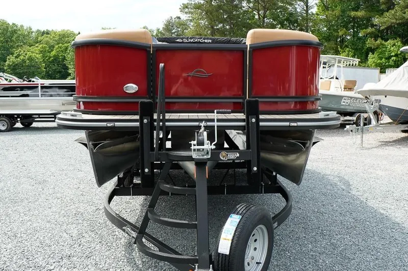 Slide: The Image of 2026 SunCatcher Fusion 324RC pontoon boat on trailer, red exterior, parked outdoors. - 3