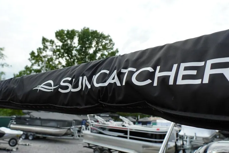 Slide: The Image of Close-up of SunCatcher Fusion 324RC boat cover, 2026 model, with boats in background. - 31