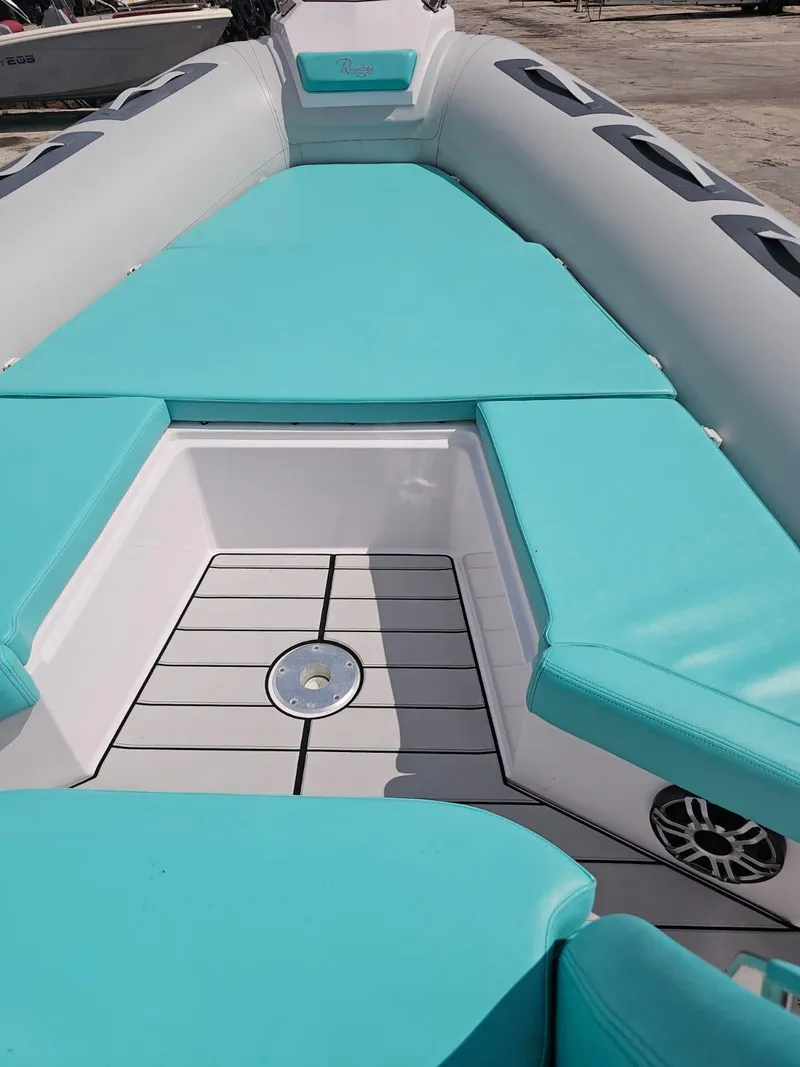 Slide: The Image of 2025 Ranieri CAYMAN 27.0 SPORT TOURING boat with turquoise seating and deck. - 11