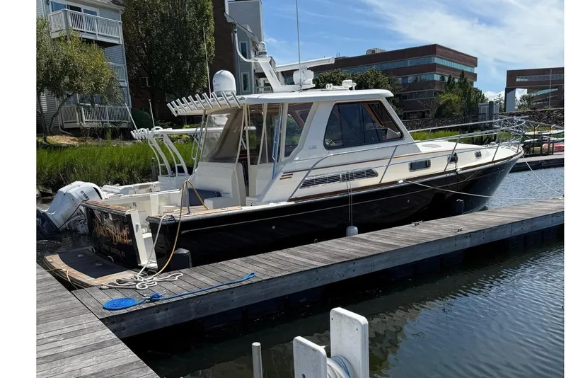 Slide: The Image of 2006 Sabre 38 Salon Express yacht docked at marina under clear blue sky. - 1