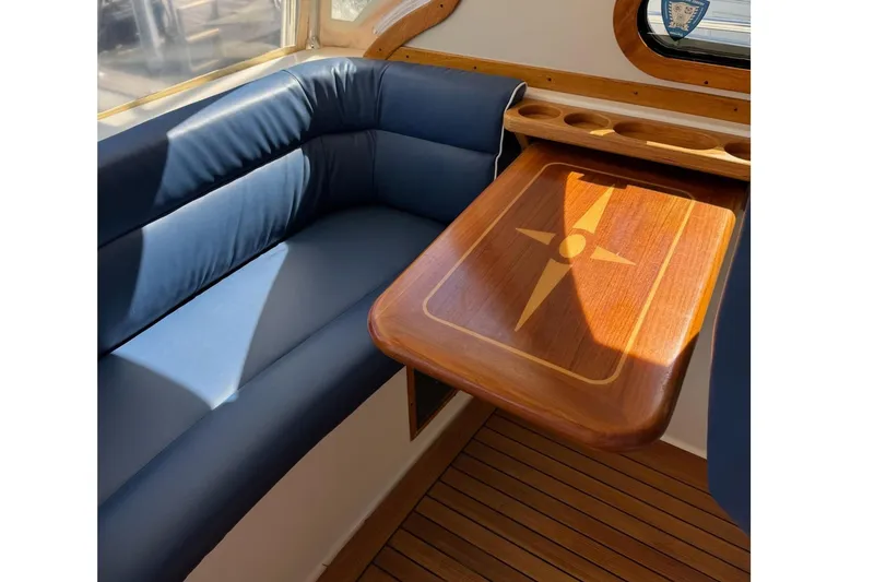 Slide: The Image of Interior of 2006 Sabre 38 Salon Express with blue seating and wooden table. - 11