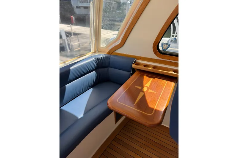 Slide: The Image of Interior of 2006 Sabre 38 Salon Express with blue seating and wooden table. - 13
