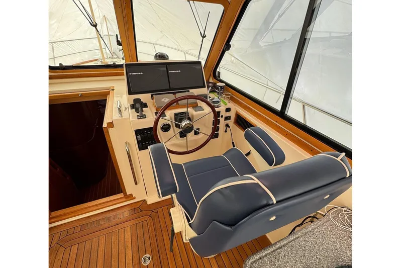 Slide: The Image of 2006 Sabre 38 Salon Express helm with wooden accents and blue captain's chair. - 16