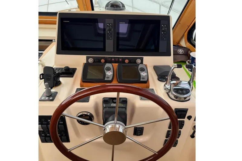 Slide: The Image of Helm of 2006 Sabre 38 Salon Express with dual screens and wooden steering wheel. - 19