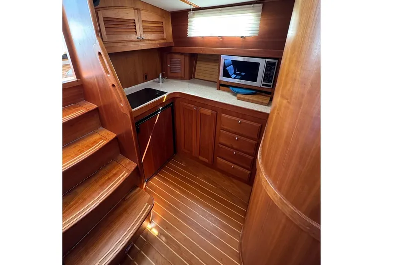 Slide: The Image of 2006 Sabre 38 Salon Express galley with wooden cabinetry, stairs, and modern appliances. - 24