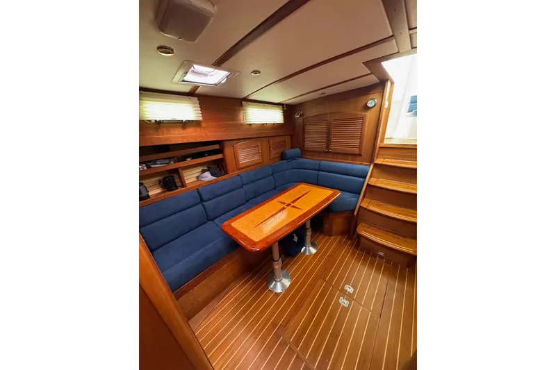 Slide: The Image of Interior of 2006 Sabre 38 Salon Express with blue seating and wooden table. - 25