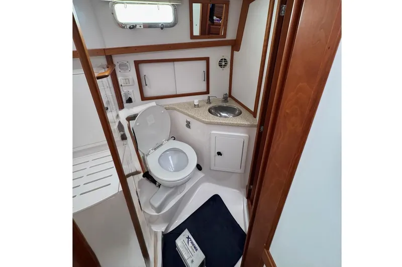 Slide: The Image of 2006 Sabre 38 Salon Express bathroom with wood accents, sink, and toilet. - 27