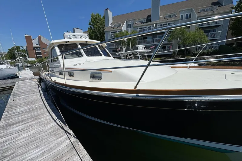 Slide: The Image of 2006 Sabre 38 Salon Express yacht docked at marina, sunny day, residential backdrop. - 3