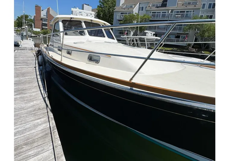 Slide: The Image of 2006 Sabre 38 Salon Express yacht docked at marina under clear blue sky. - 4