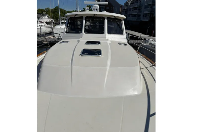 Slide: The Image of 2006 Sabre 38 Salon Express yacht docked at marina, showcasing sleek deck design. - 5