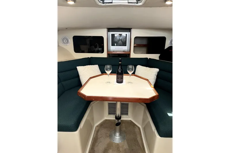 Slide: The Image of 2005 Albin 28 Tournament Express cabin with table, wine, and glasses. Cozy interior setting. - 11