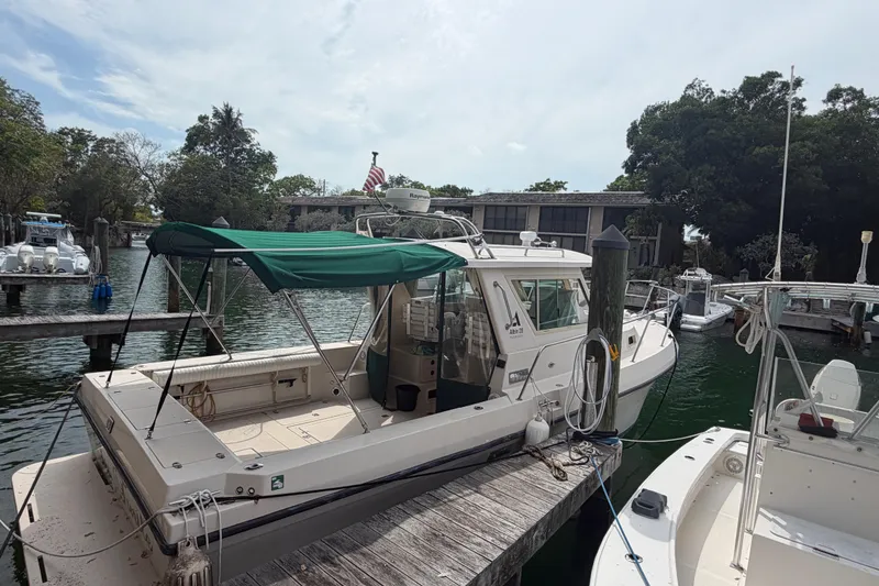 Slide: The Image of 2005 Albin 28 Tournament Express docked at a marina with green canopy. - 2