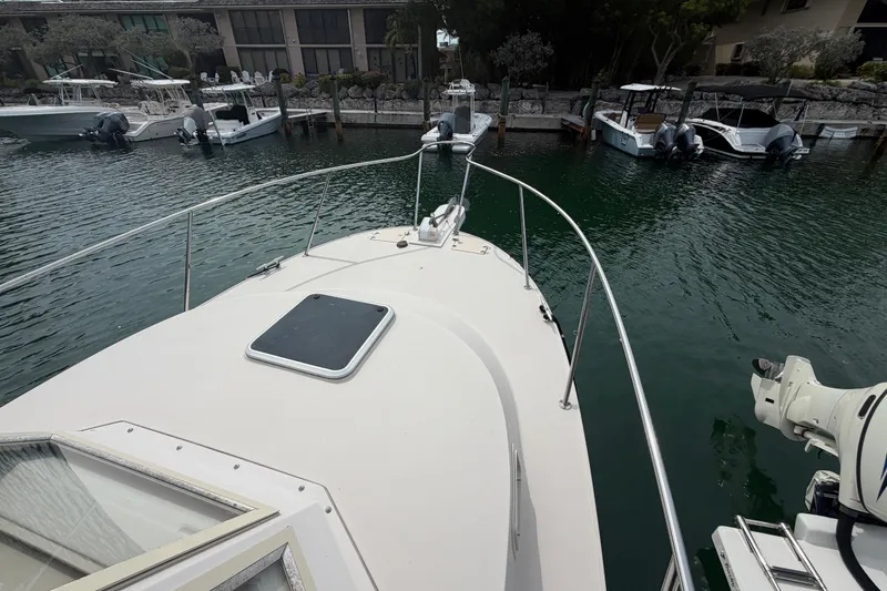 Slide: The Image of 2005 Albin 28 Tournament Express boat docked in a marina, surrounded by calm water. - 23