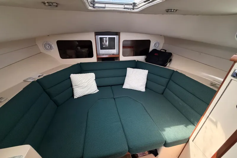Slide: The Image of 2005 Albin 28 Tournament Express cabin with green seating and pillows. - 7