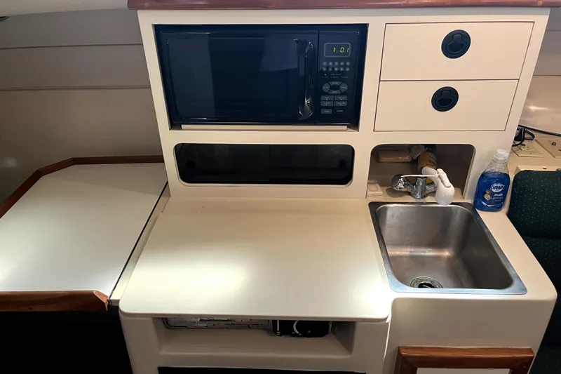 Slide: The Image of Compact galley in 2005 Albin 28 Tournament Express with microwave, sink, and storage. - 9