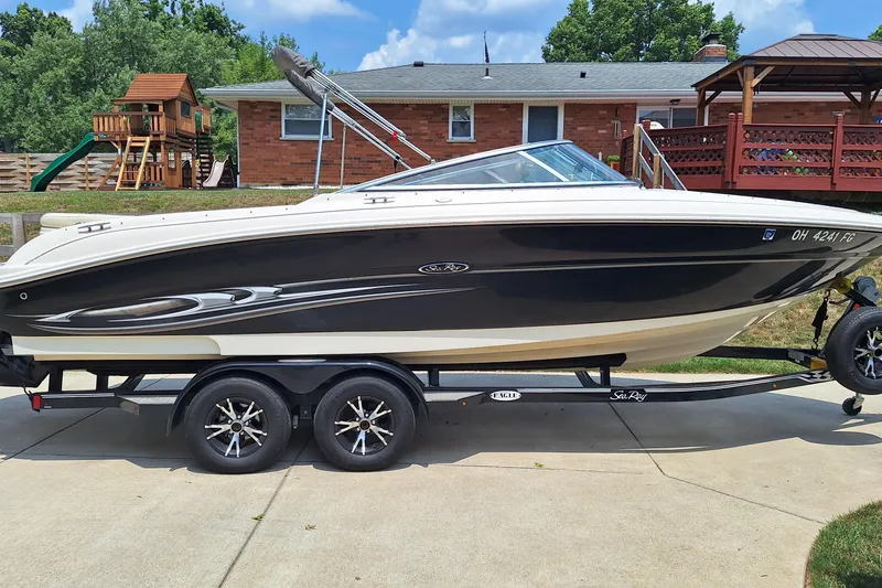 The Image of 2004 Sea Ray 240 Select boat on trailer in residential driveway. - 1
